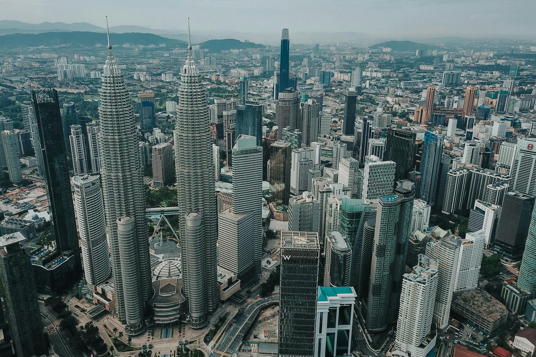 Aerial view Kuala Lumpur city with famous Petronas Twin Towers surrounded with glass skyscrapers and urban architecture